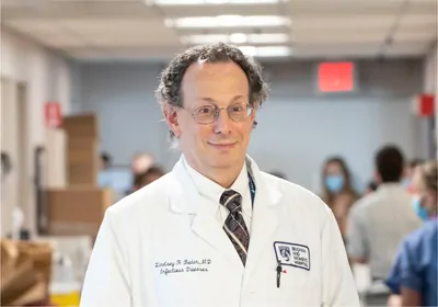 Man in lab coat looking at the camera and smiling